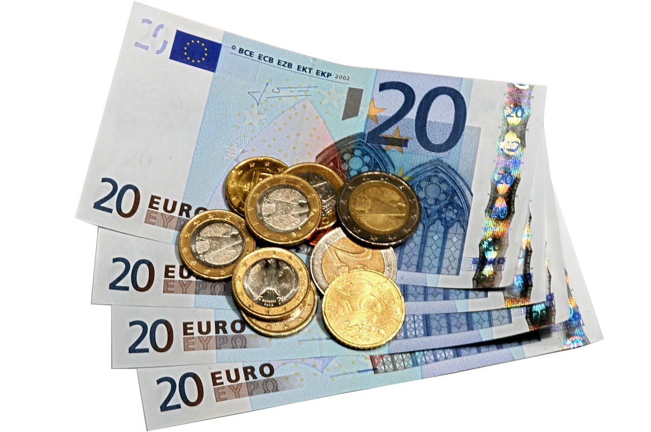Eurobankbiljetten en -munten op een witte achtergrond.