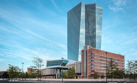 De Europese Centrale Bank in Frankfurt. Modern kantoorgebouw met hoge glazen toren tegen een blauwe lucht.