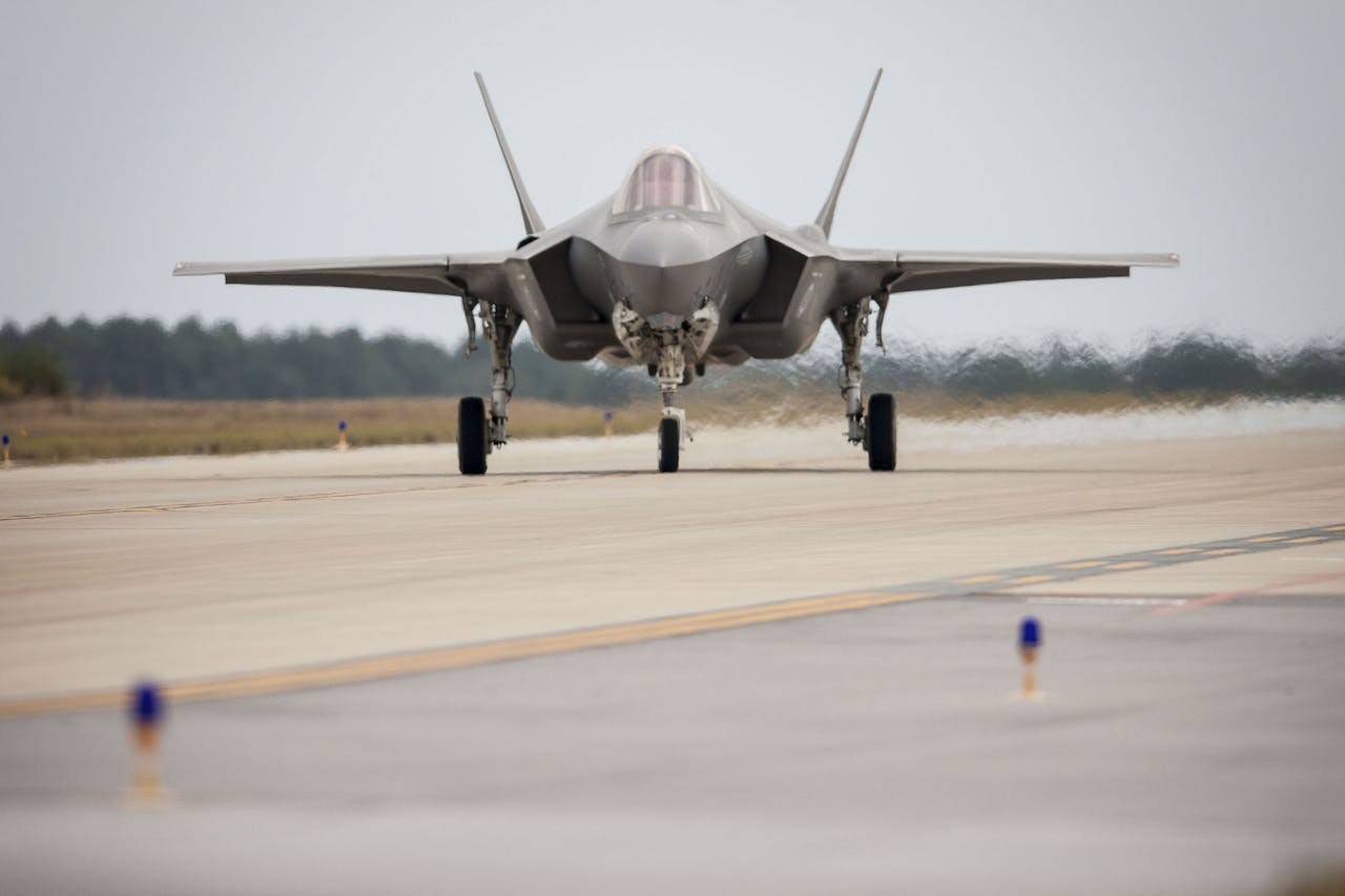 Een grijze straaljager op een startbaan van grijs asfalt.