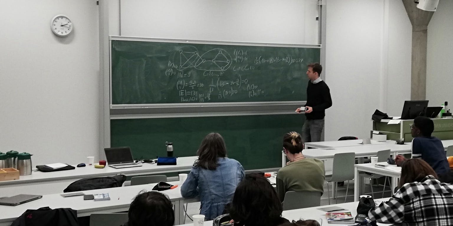 Een docent die lesgeeft aan zijn studenten.