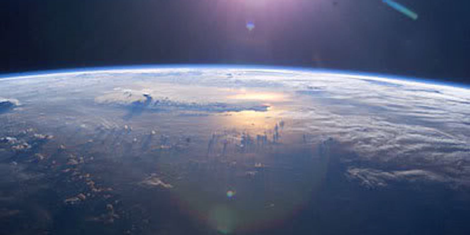 De zon schijnt vanuit de ruimte over de aarde.