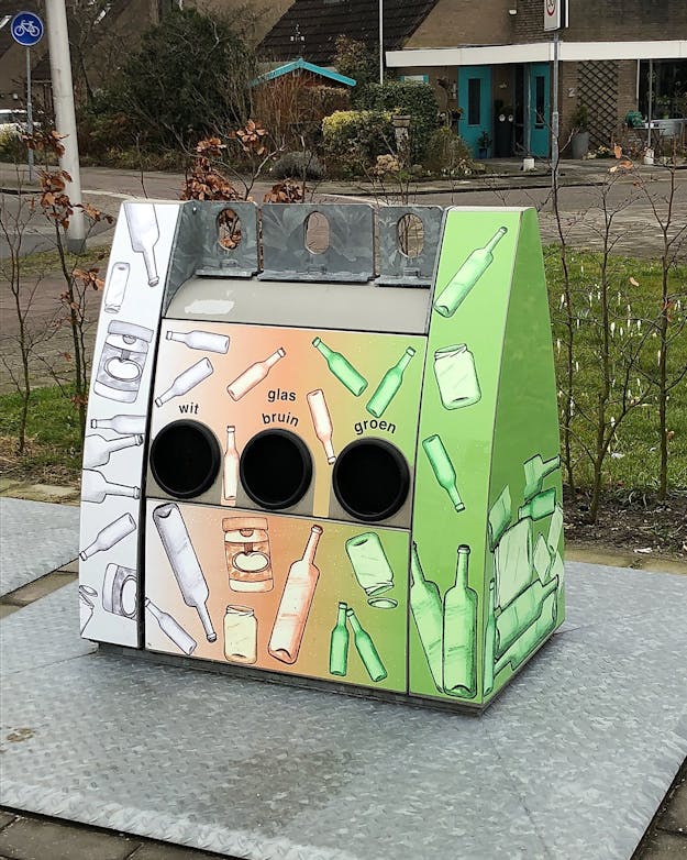 Een glasbak op een metalen grondplaat met een drie openingen. Een glasbak op een metalen grondplaat met een drie openingen.