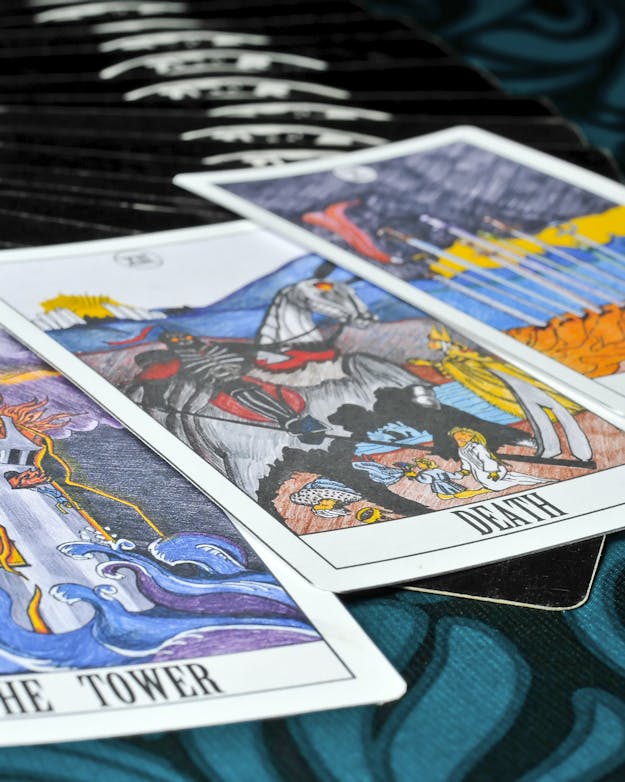 Als iemand ver boven kansniveau dezelfde kaart trekt, is het dan geen toeval meer? Drie Engelse tarotkaarten op tafel: the tower, death en ten of swords