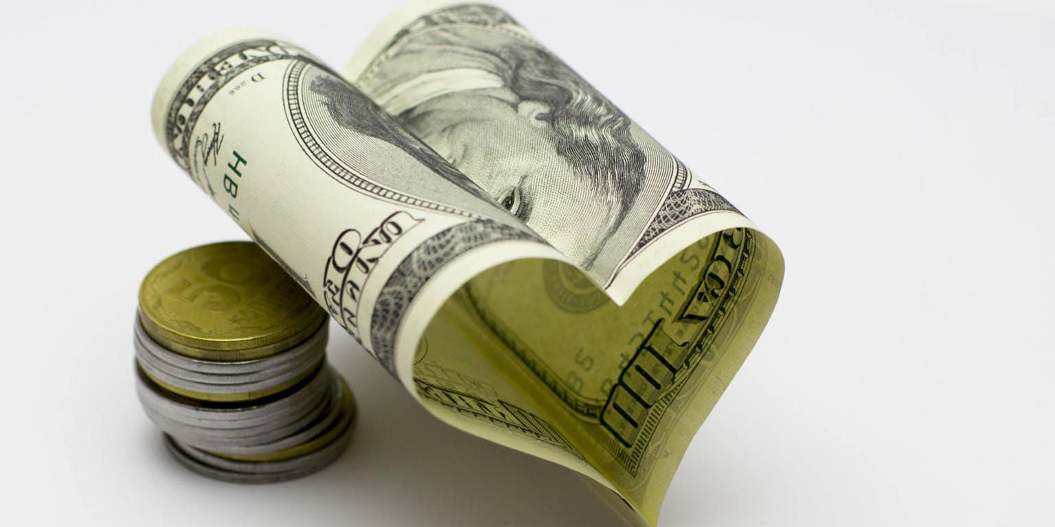 Een stapel geld in de vorm van een hart.