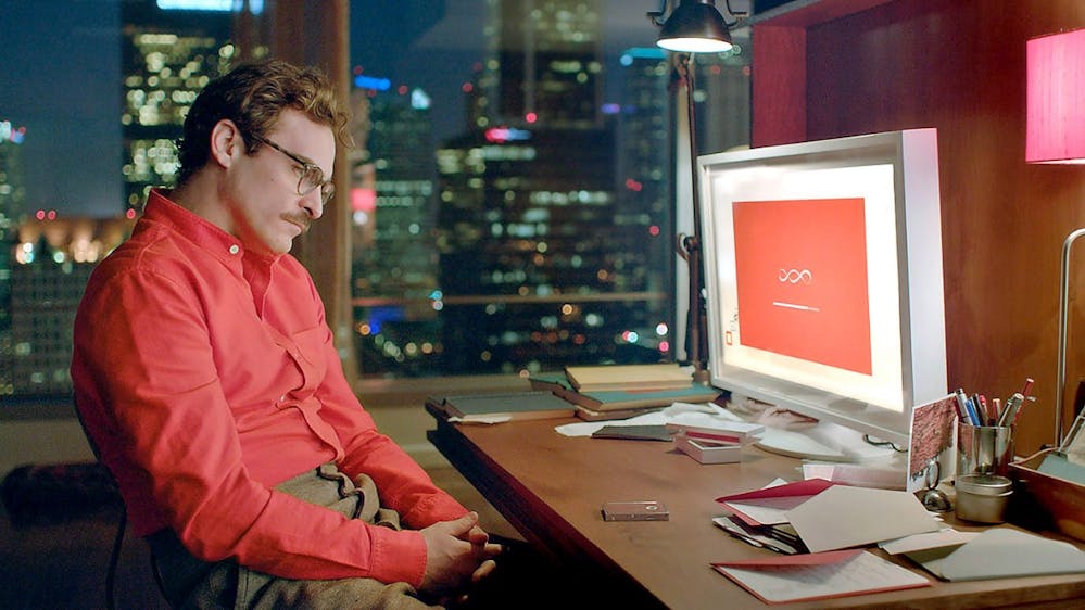 Hoofdpersoon Theodore uit de film 'Her' staart naar zijn computerscherm, terwijl AI-besturingssysteem Samantha tot leven komt.