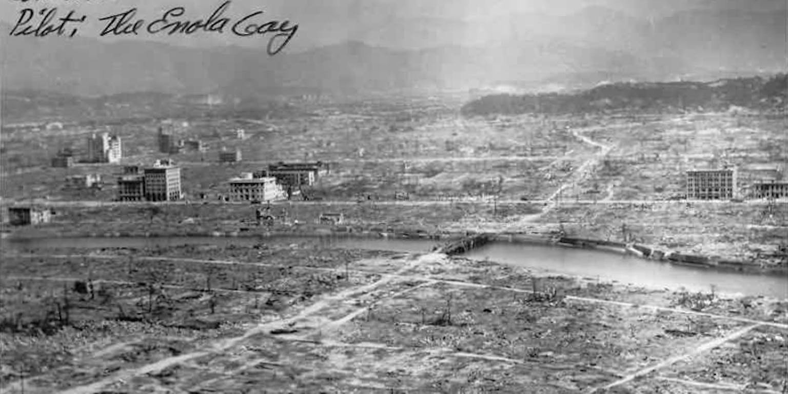 Een zwart-wit foto van Hiroshima, na de atoombom. Op de foto is een handschrift van de piloot Paul Tibbets te lezen.