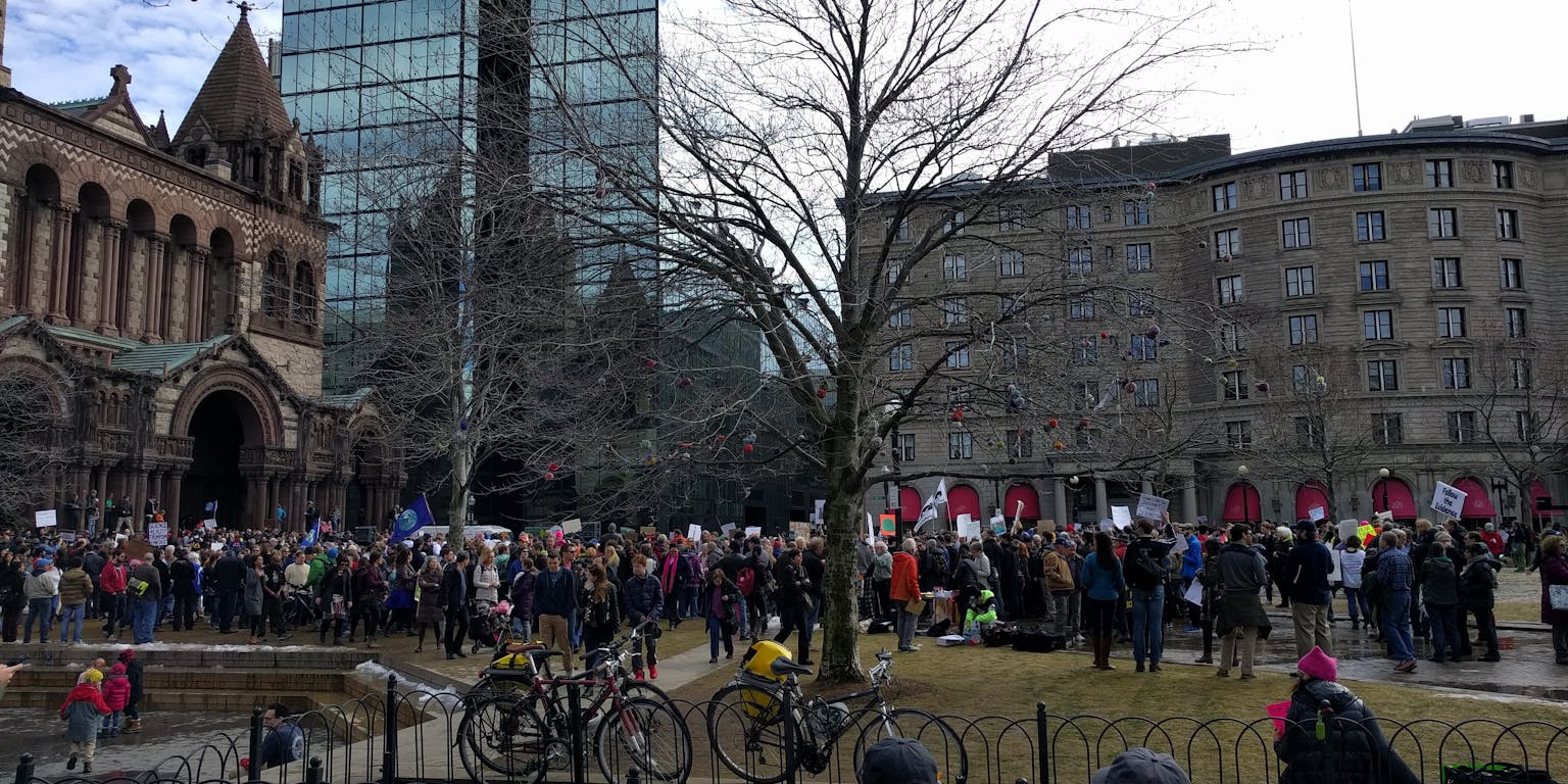 Een grote groep mensen staat voor een gebouw.