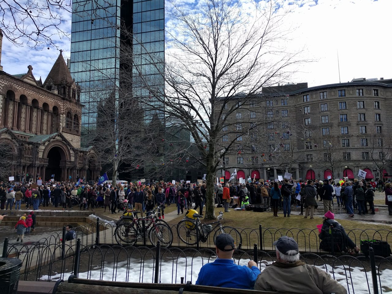 Een grote groep mensen staat voor een gebouw.