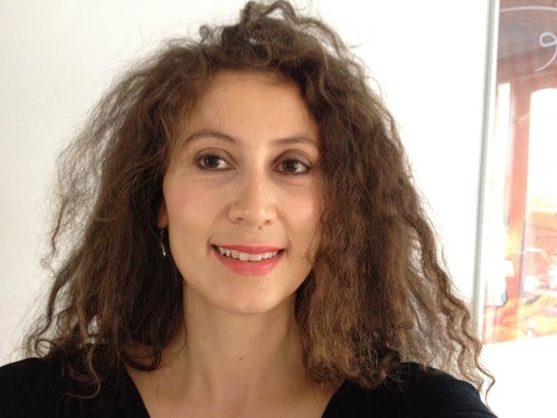 Britta van Beers Een vrouw met krullend haar lacht naar de camera.