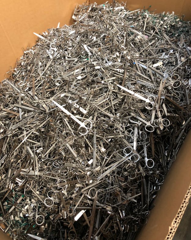 Een grote kartonnen doos vol met metalen scharen. Een grote kartonnen doos vol met metalen scharen.