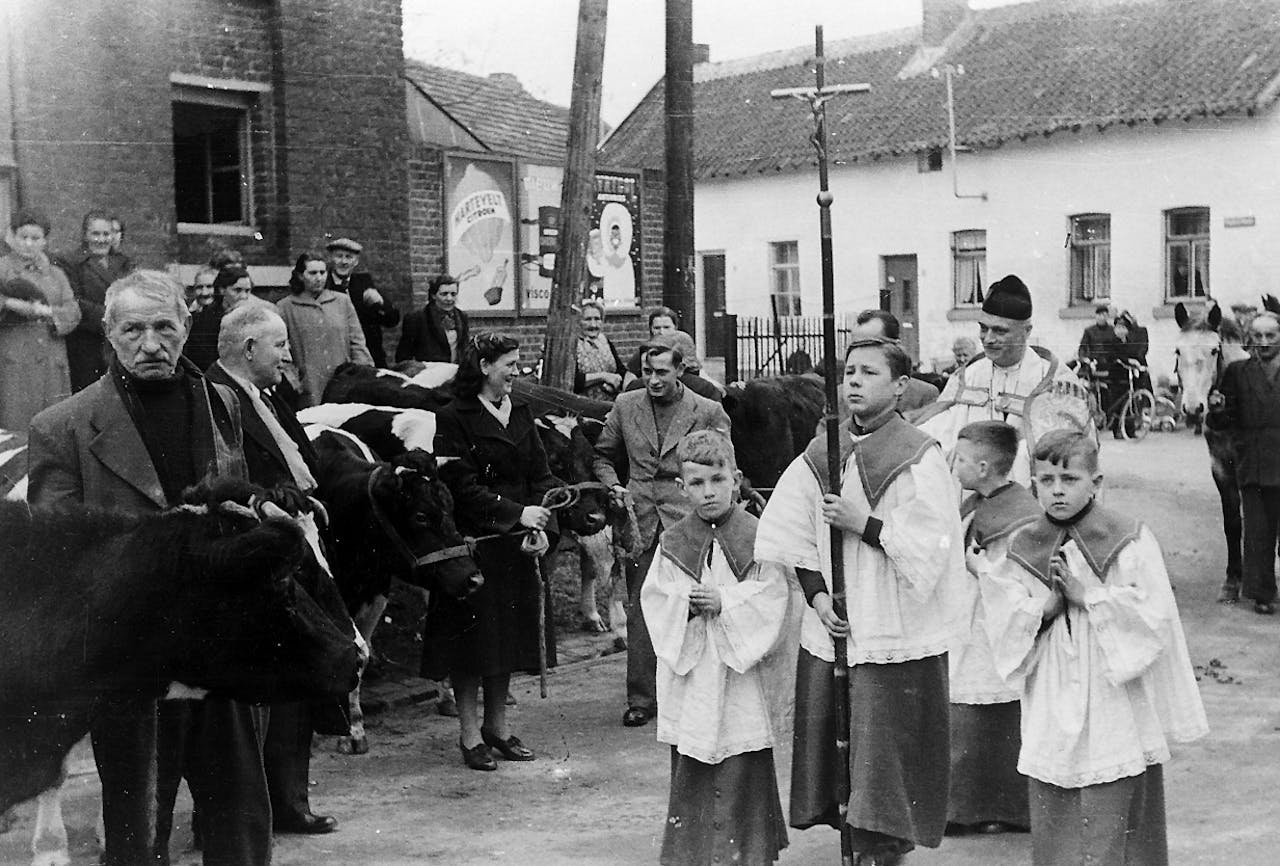 Een zwart-witfoto uit 1955. In kleine processie trekt pastoor A. Schutgens ter zegening door de Brigidastraat in het Limburgse dorp Itteren.