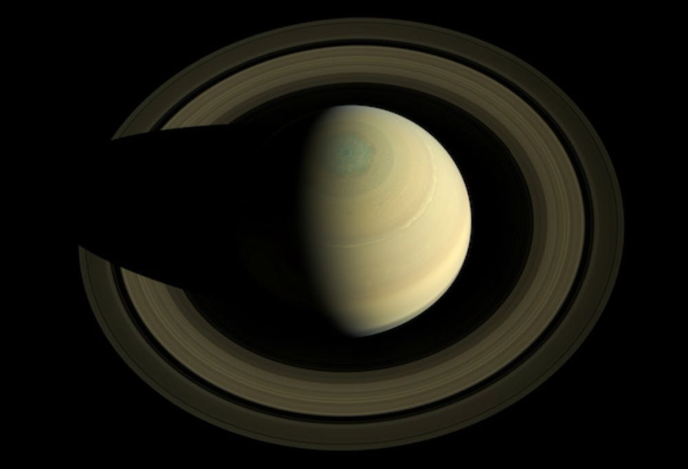 <p>De ringen van Saturnus gezien door Cassini, hoog boven de zeshoekige noordpool van de planeet.</p>