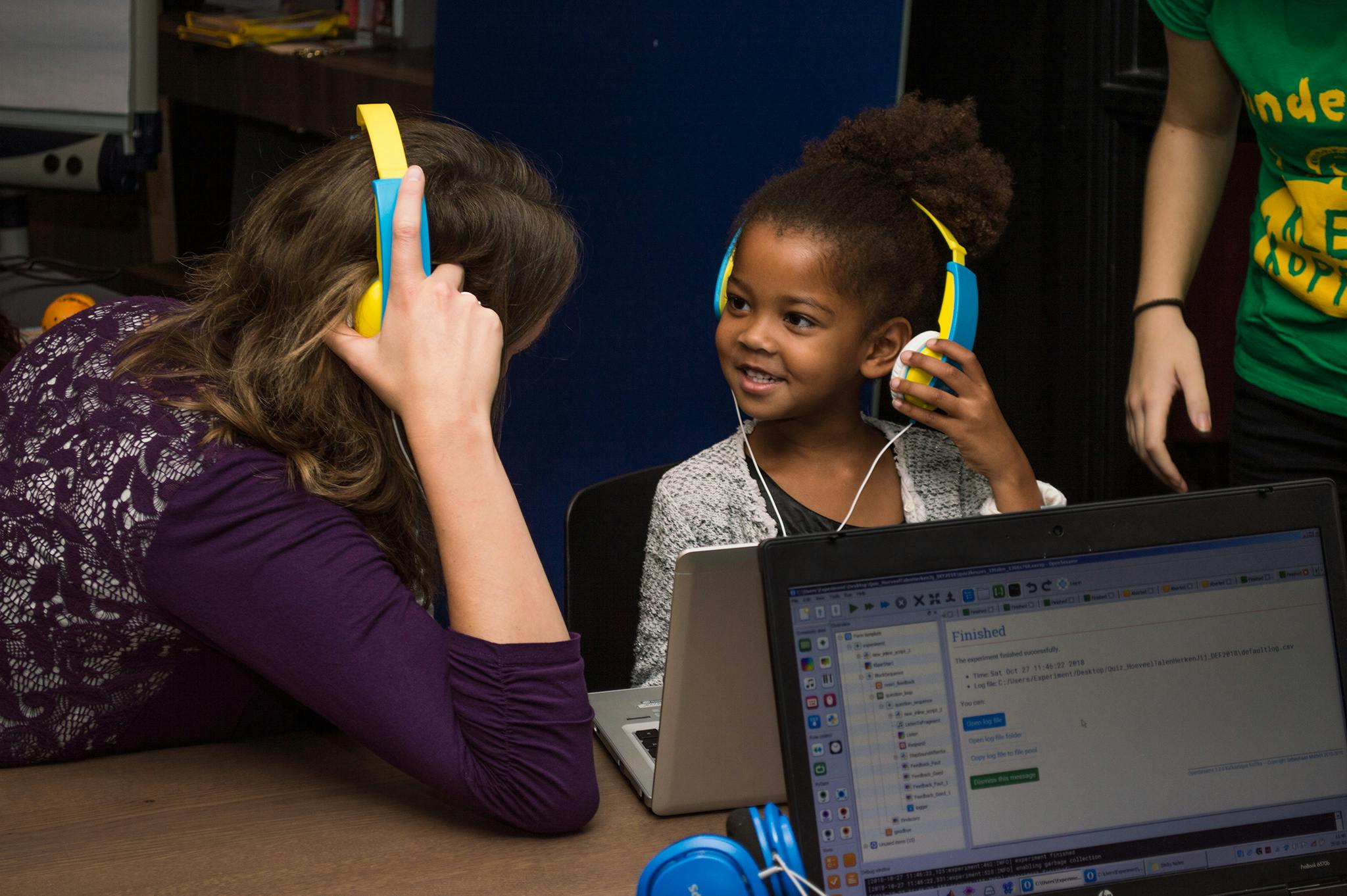 Een vrouw en een kind met dezelfde koptelefoon op.