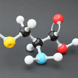 Een model van een chemisch molecuul op een zwart oppervlak.
