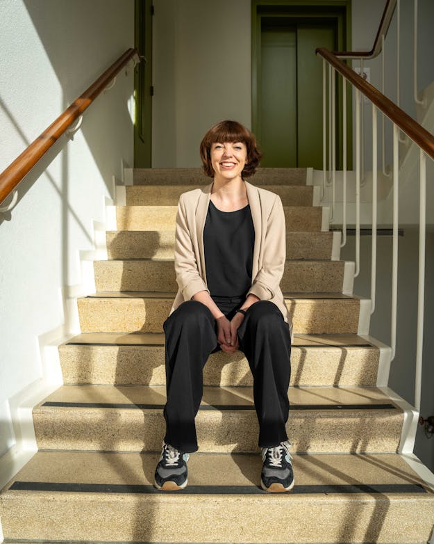 Maaike Harbers. Maaike Harbers zittend op een trap.