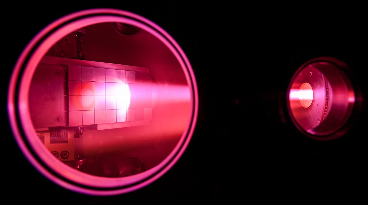 Een close-up van gemagnetiseerd plasma met roze licht in een donkere ruimte.