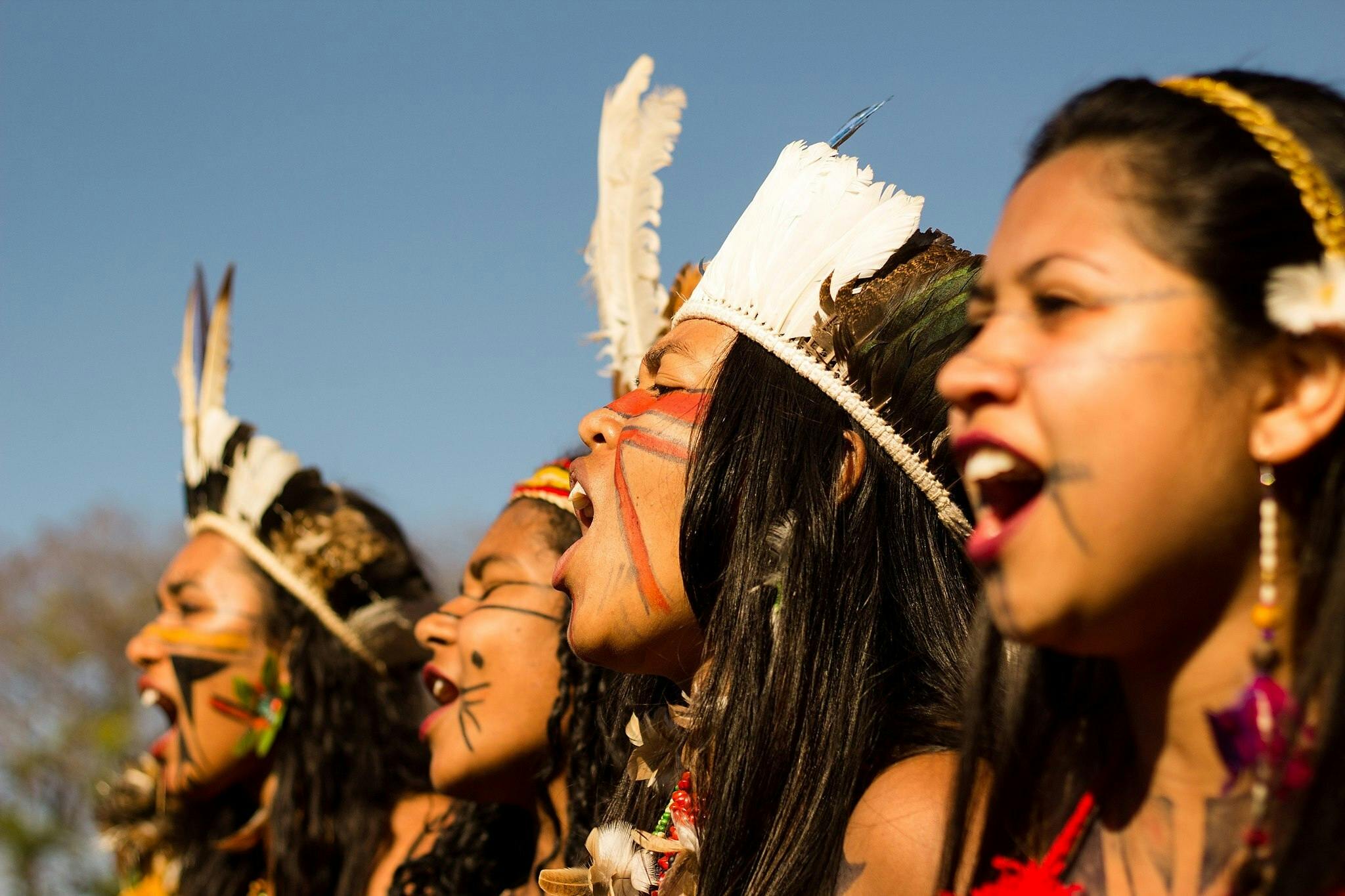 Een groep vrouwen zingt in de open lucht tijdens Marcha Das Mulheres Indigenas.
