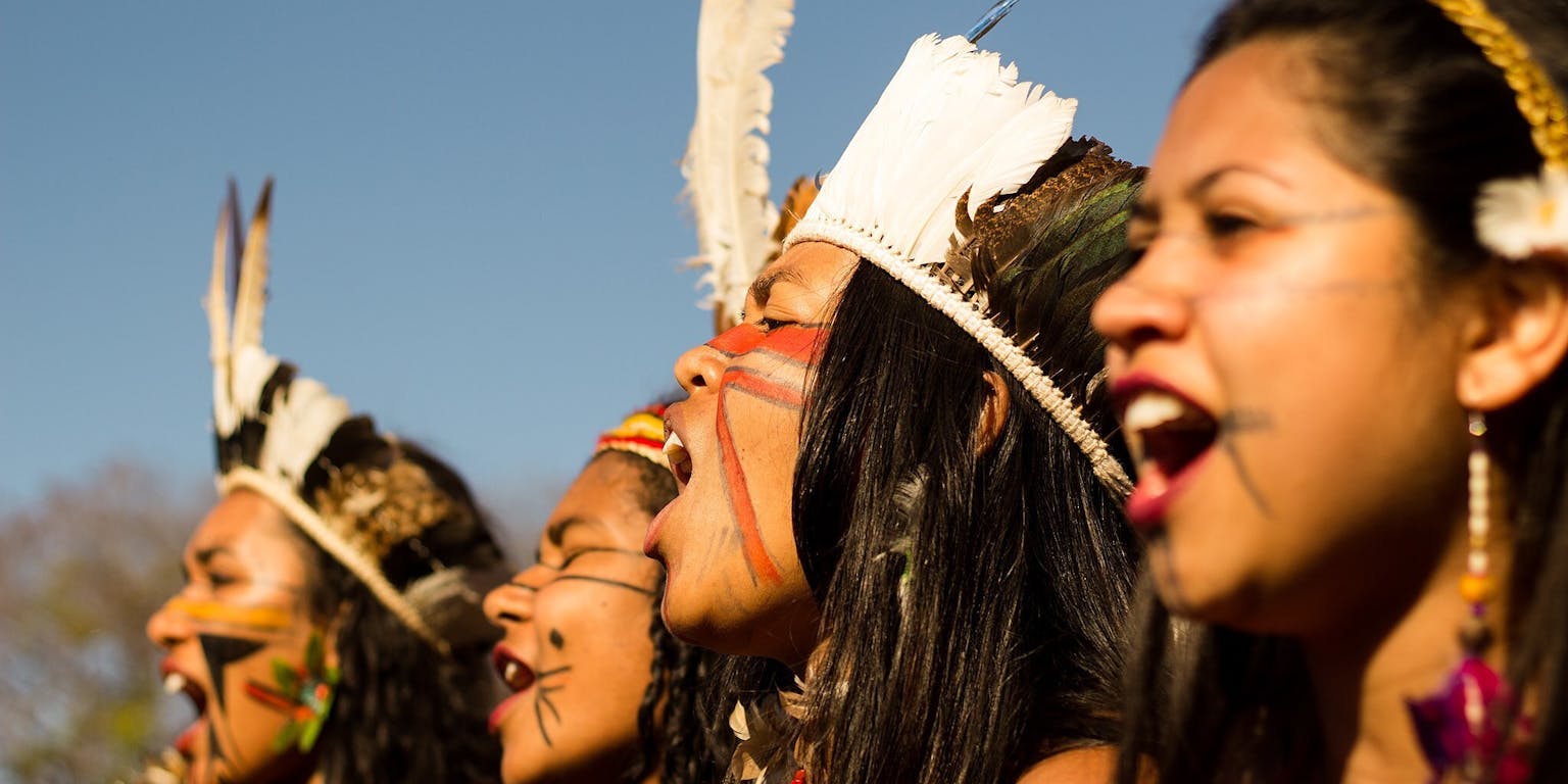 Een groep vrouwen zingt in de open lucht tijdens Marcha Das Mulheres Indigenas.