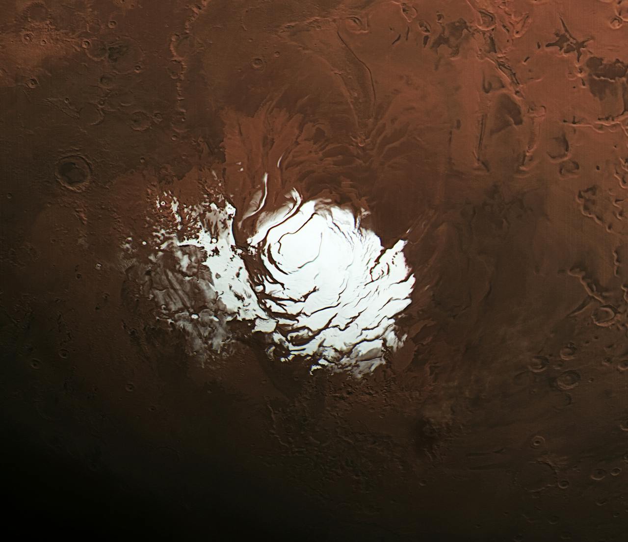 De zuidpool van Mars gefotografeerd door Mars Express. Het oppervlak van Mars is hier bedekt met een kilometers dikke ijslaag (tot bijna vijf kilometer soms). Pas de afgelopen jaren is de ruimtesonde in staat geweest om dit gebied met radar in een hoge resolutie te onderzoeken.