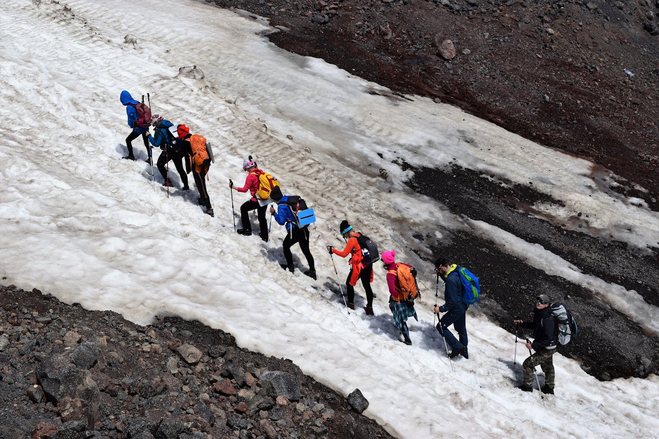 Een groep mensen die een besneeuwde berg beklimmen.