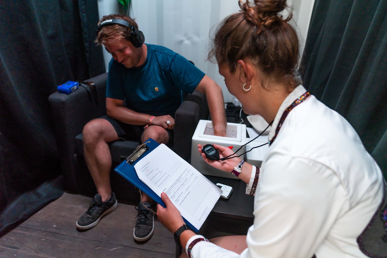 Deelnemer zit met zijn hand in een bak met ijs om te testen of muziek werkt als medicijn tijdens Lowlands Science 2023