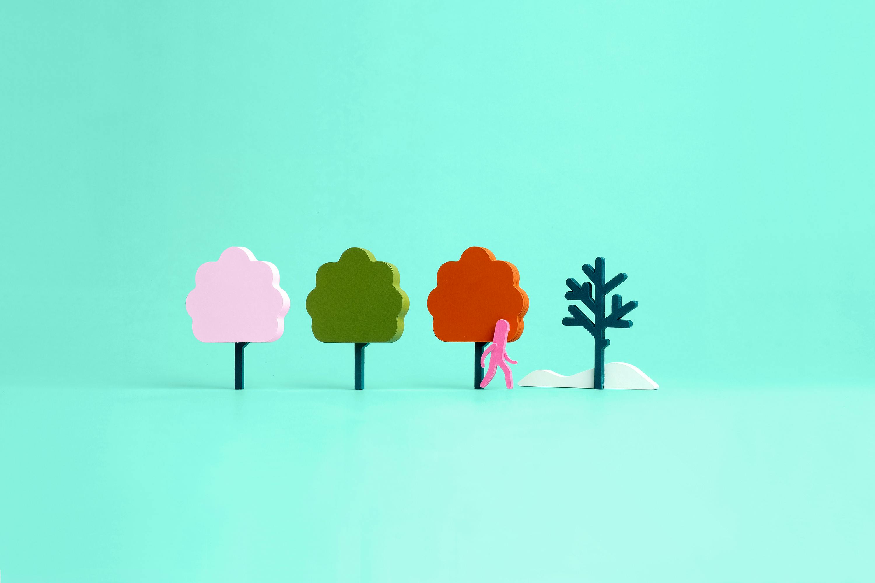 Poppetje loopt langs vier bomen in de vier jaargetijden: eerst lente, zomer en herfst, loopt nu richting de kale boom in de winter