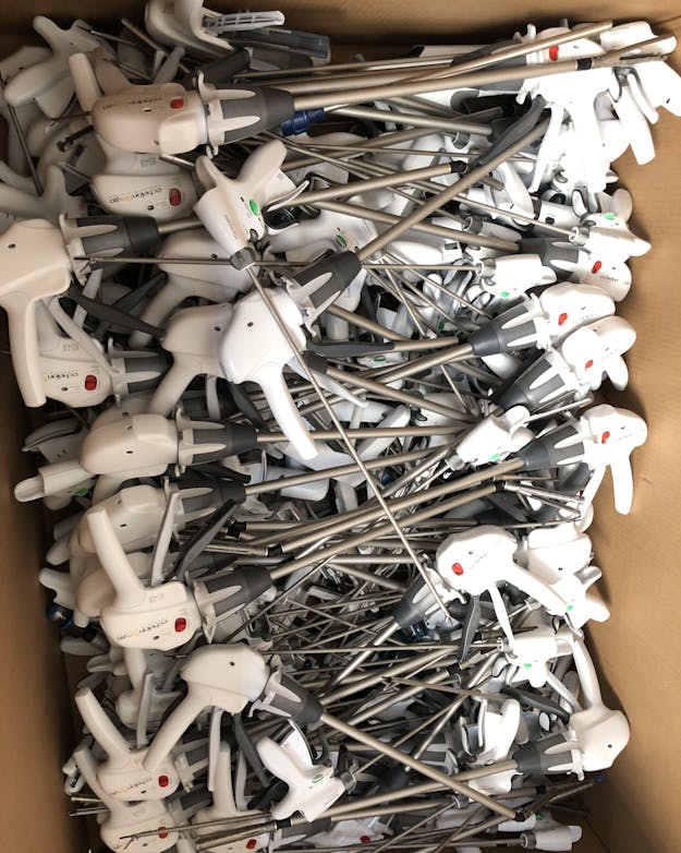 Kartonnen doos vol met medische nietmachines. Deze hebben een wit handvat van kunststof en daar steekt een stalen pin uit. Kartonnen doos vol met medische nietmachines. Deze hebben een wit handvat van kunststof en daar steekt een stalen pin uit.