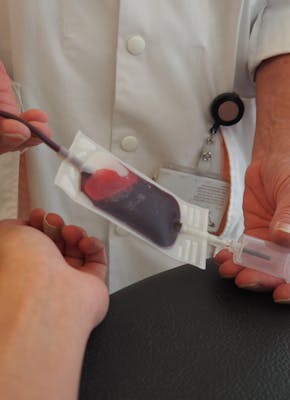 Een arts die een bloedmonster afneemt bij een bloeddonor.