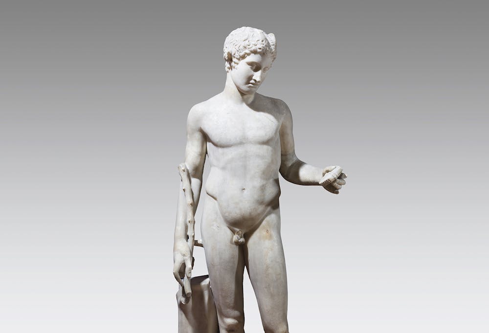 <p>Marmer, Romeins, 50-350 na Chr., h. 109.8 cm. De natuurgod Pan is weergegeven als een naakte jongen, met horentjes op zijn hoofd. In zijn linkerhand houdt hij een panfluit, in de rechter een herdersstaf. De jeugdige god staat in een klassieke contrapost-houding, een uitvinding van de Griekse beeldhouwers in de vijfde eeuw v.Chr. Zijn gewicht rust op zijn rechterbeen, het linkerbeen is schuin opzij geplaatst. Hierdoor krijgt zijn lichaam een lichte dynamische curve. Dit beeld is een Romeinse kopie, gemaakt naar een Grieks origineel van de beeldhouwer Polykleitos.</p>