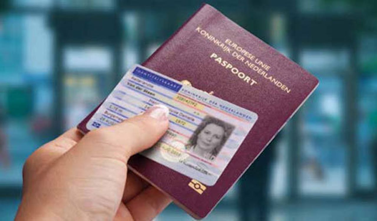 Een persoon met een paspoort en identiteitsbewijs in de hand.