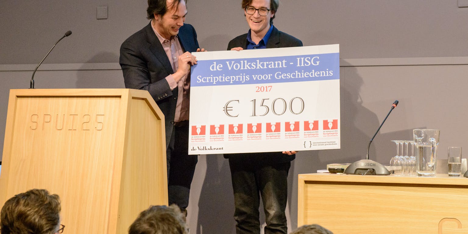 Olav Hofland wint de Volkskrant-IISG Scriptieprijs 2017. Juryvoorzitter Jouke Turpijn reikt de cheque van 1500 euro uit.