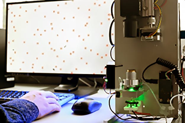 Continue biosensor gebaseerd op deeltjesbeweging. Een groene LED beschijnt de deeltjes. Een camera daarboven neemt videobeelden op van de deeltjes. Op het computerscherm zijn de camerabeelden zichtbaar. De deeltjes zijn heel klein: 1 micrometer. Continue biosensor gebaseerd op deeltjesbeweging. Een groene LED beschijnt de deeltjes. Een camera daarboven neemt videobeelden op van de deeltjes. Op het computerscherm zijn de camerabeelden zichtbaar. De deeltjes zijn heel klein: 1 micrometer.