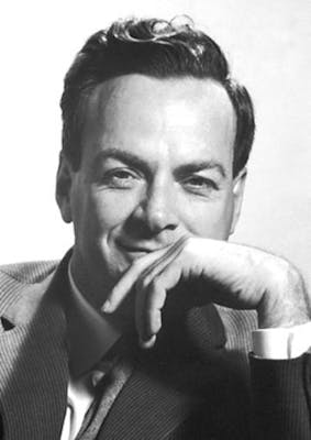 Richard Feynman die met een lach de camera inkijkt.
