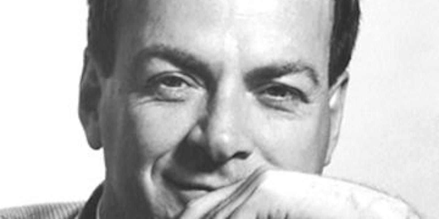 Richard Feynman die met een lach de camera inkijkt.
