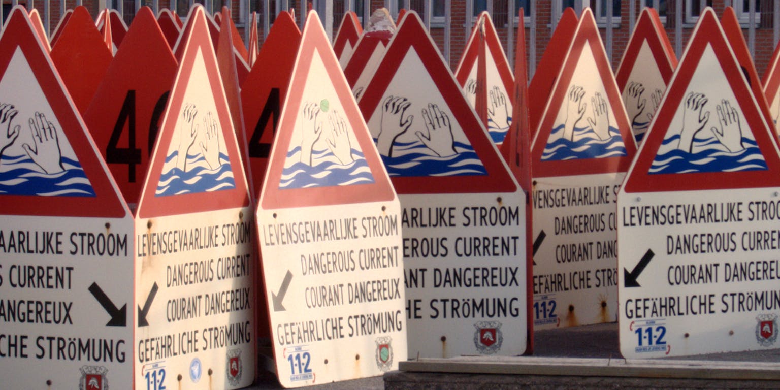 Een groep waarschuwingsborden met de tekst: levensgevaarlijke stroom. De tekst is zichtbaar in verschillende talen.