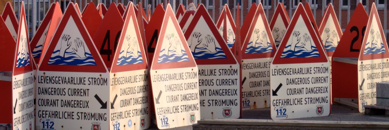 Een groep waarschuwingsborden met de tekst: levensgevaarlijke stroom. De tekst is zichtbaar in verschillende talen.