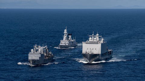Het Nederlandse amfibisch transportschip Zr.Ms. Johan de Witt (rechts) in gezelschap van de Franse bevoorrader Var et Marne en het luchtverdedigingsfregat Forbin. Drie grijze marineschepen op volle zee.