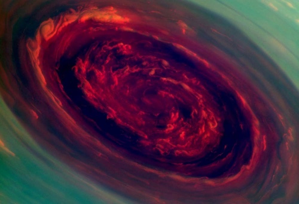 <p>De noordpool van Saturnus in beeld gebracht door de Cassini-ruimtesonde van <span class="caps">NASA</span>. We kijken hier recht in het oog van een pakweg 2000 kilometer brede superstorm. De foto is samengesteld van verschillende opnames die in groen en rood zijn weergegeven. De groene gebieden stellen ‘hoge’ bewolking voor, de rode laten lage wolken zien. Aan de buitenrand van de storm worden windsnelheden gehaald van 540 kilometer per uur.</p>