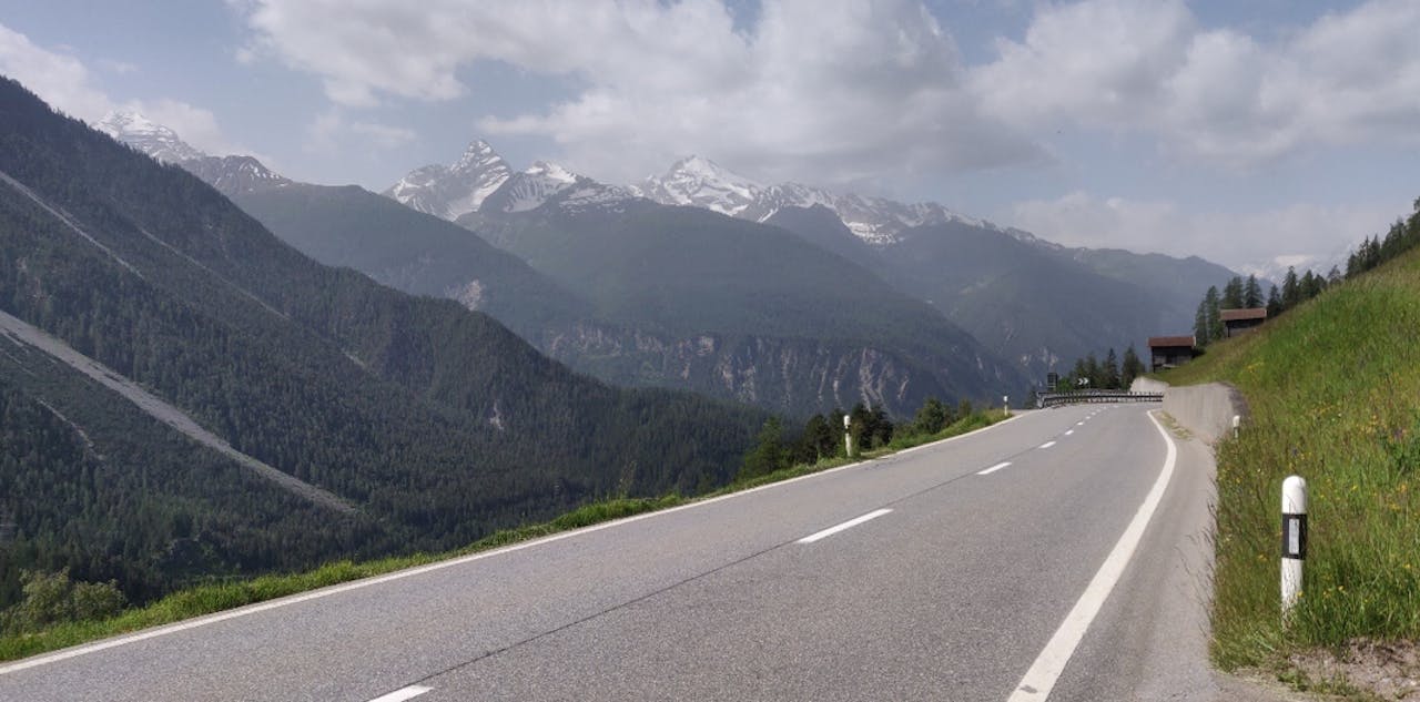 Uitzicht op de Tinzenhorn in Zwiterland, met snelweg, groen gas en besneeuwde bergen op de achtergrond