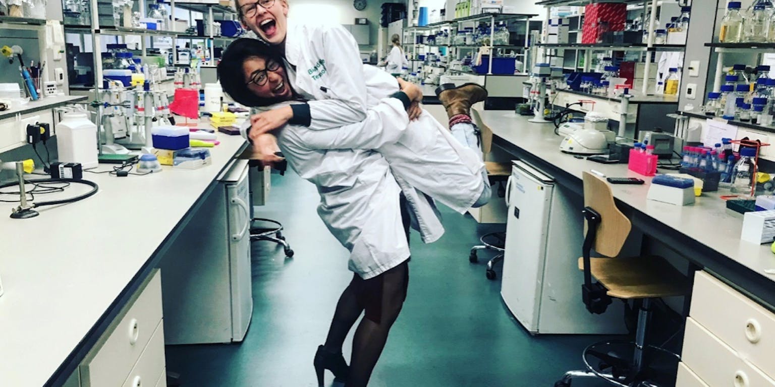 Dan Jing Wu en Eline Sijbesma omhelzen elkaar in een laboratorium.