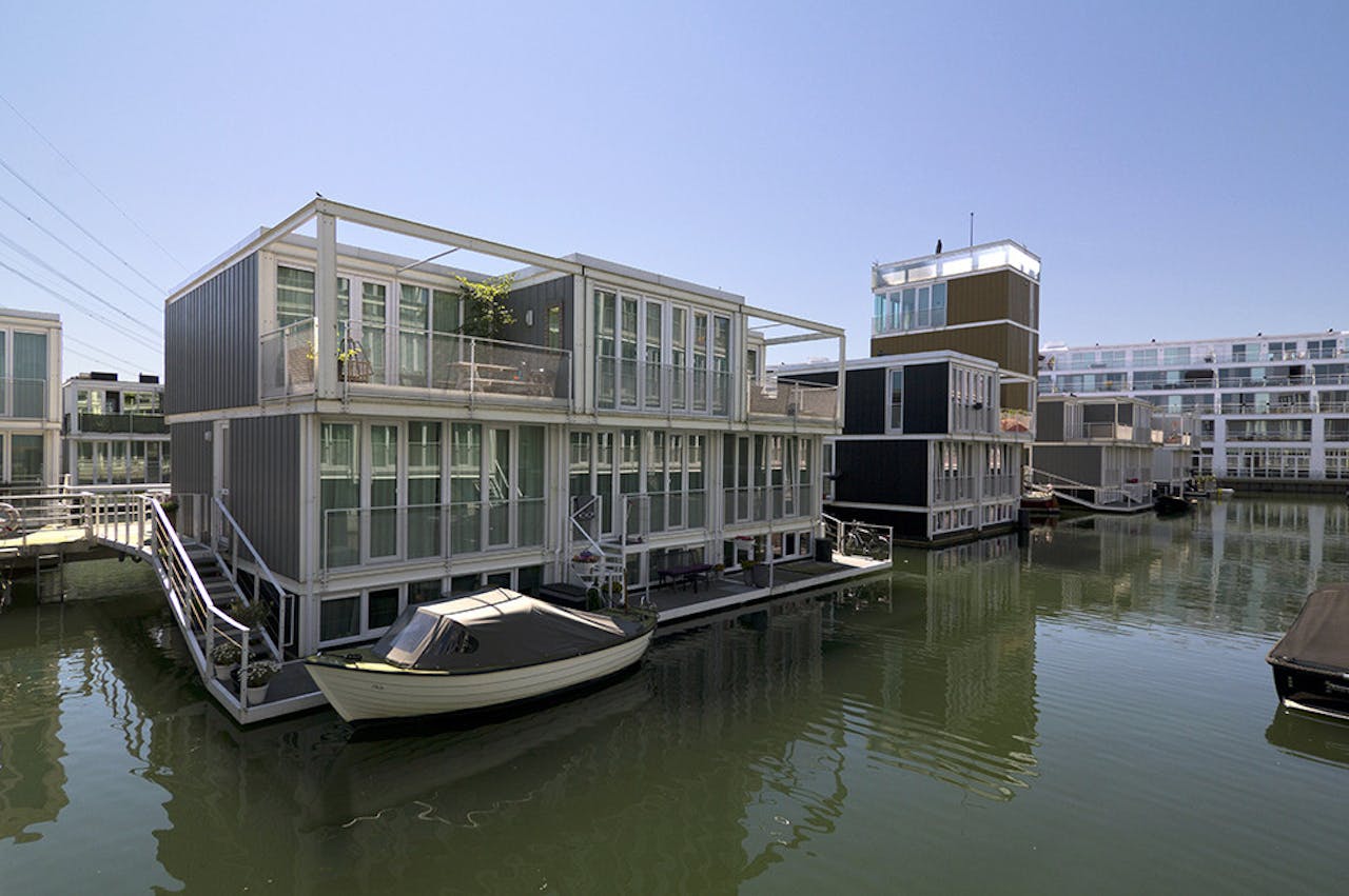 Rohmer ontwierp deze Waterwoningen op IJburg in Amsterdam. Als ze er op bezoek gaat, hoort ze van een felle discussie tussen bewoners. Je woont hier op het water en er is beperkte buitenruimte. Er wonen veel gezinnen en de kinderen willen graag buitenspelen. Misschien zijn speelbakken, groene potons of drijvende zandbakken een oplossing? Maar daar zijn kinderloze bewoners fel op tegen.