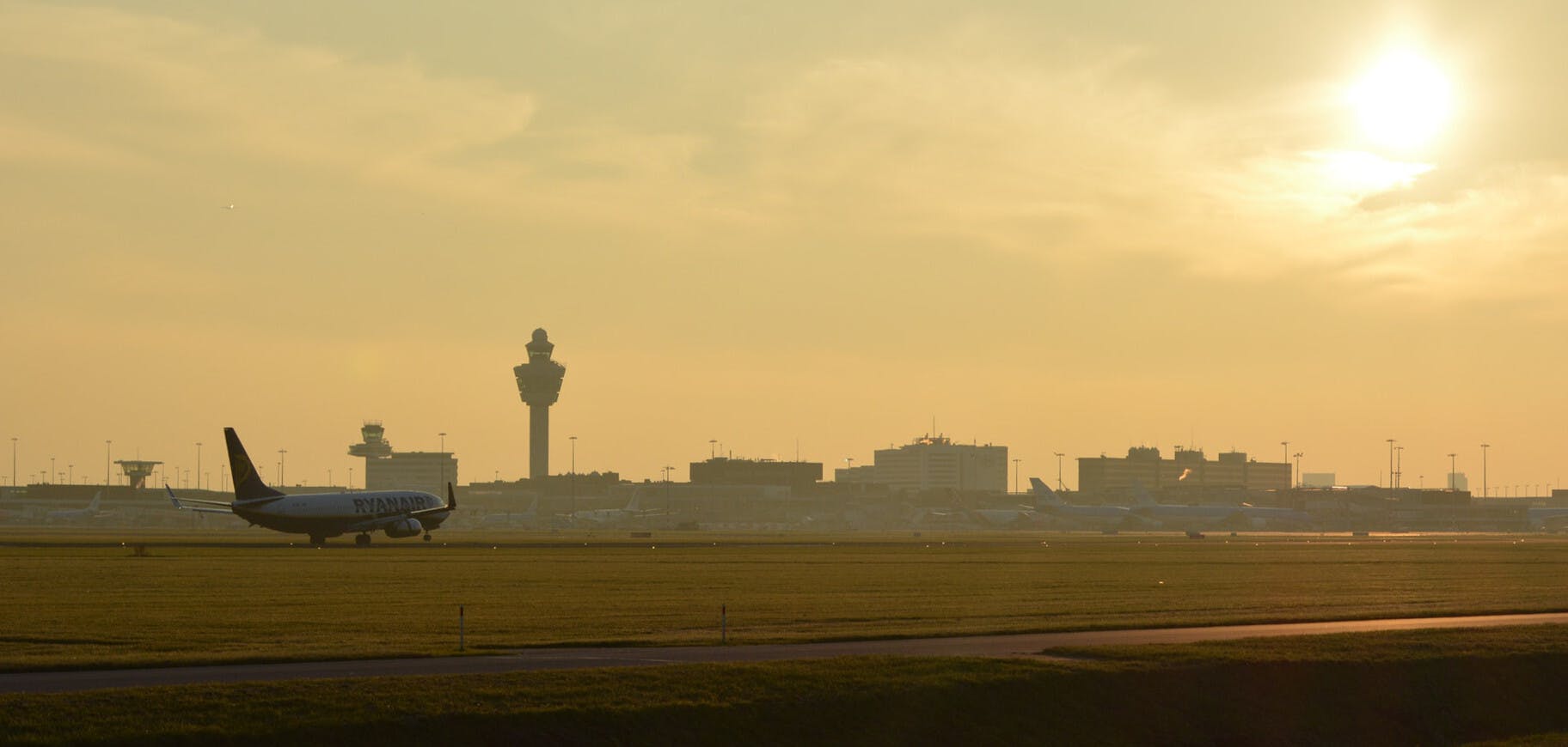 Een verkeerstoren en landingsbaan van Schiphol.