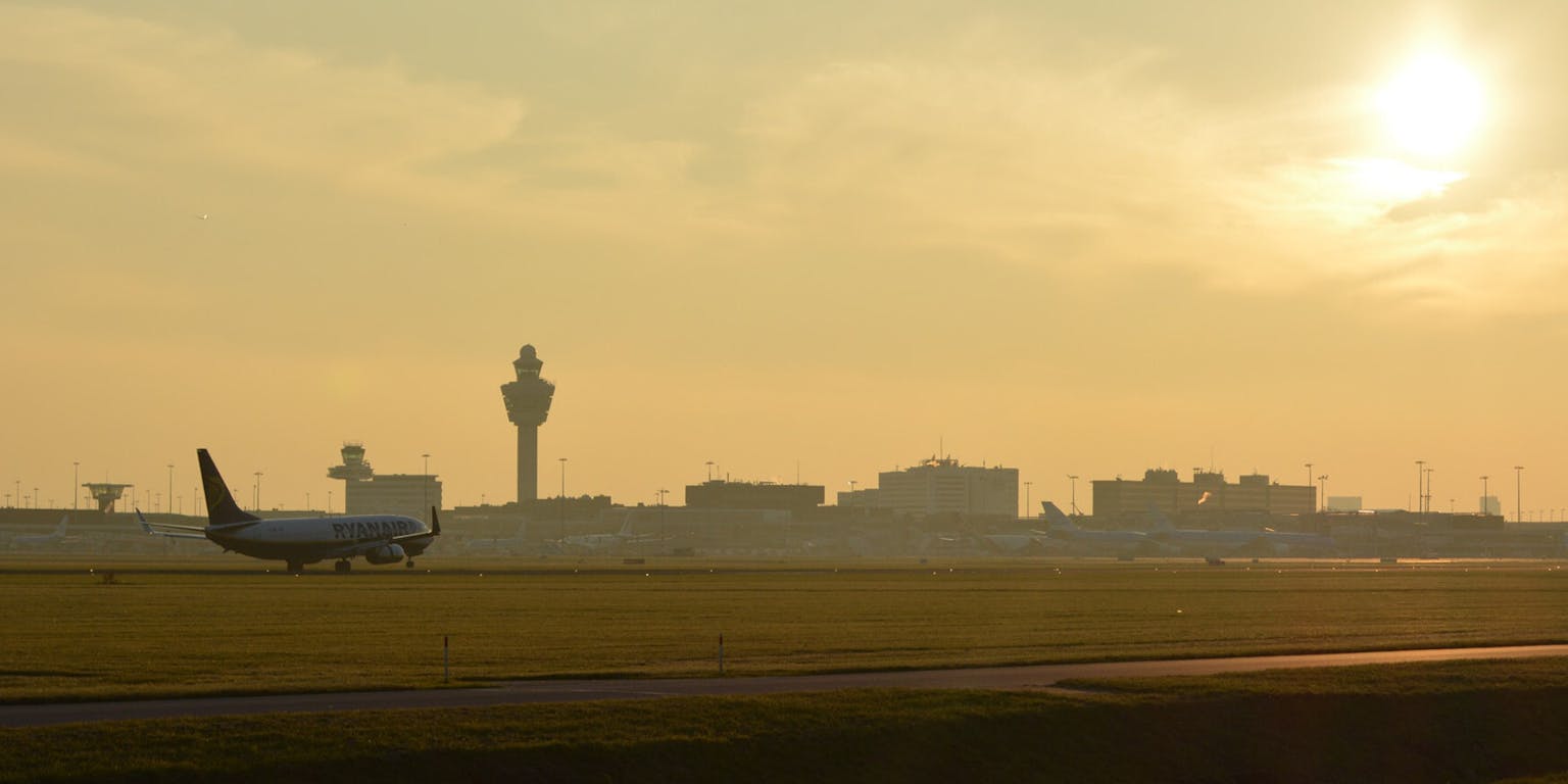 Een verkeerstoren en landingsbaan van Schiphol.