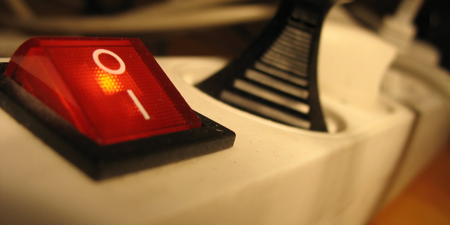 Een rode lichtschakelaar op een witte stekkerdoos.