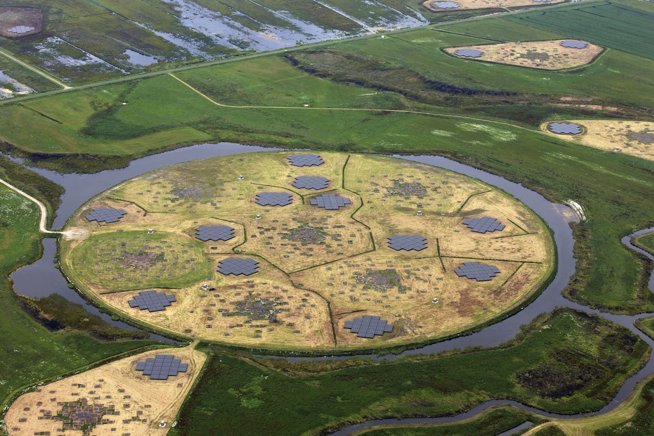 Een luchtfoto van een circulair zonnepark in een veld.