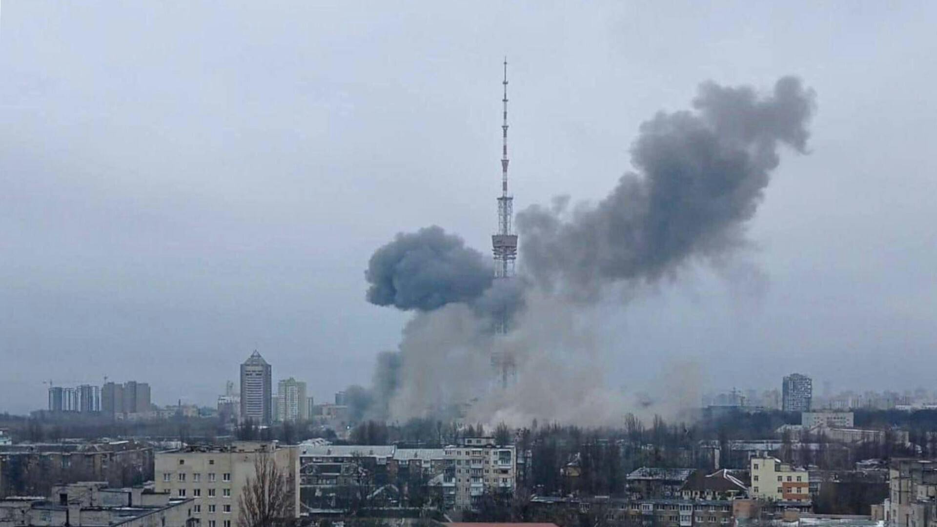 Een zwarte rook stijgt op bij een tv-toren in een stad