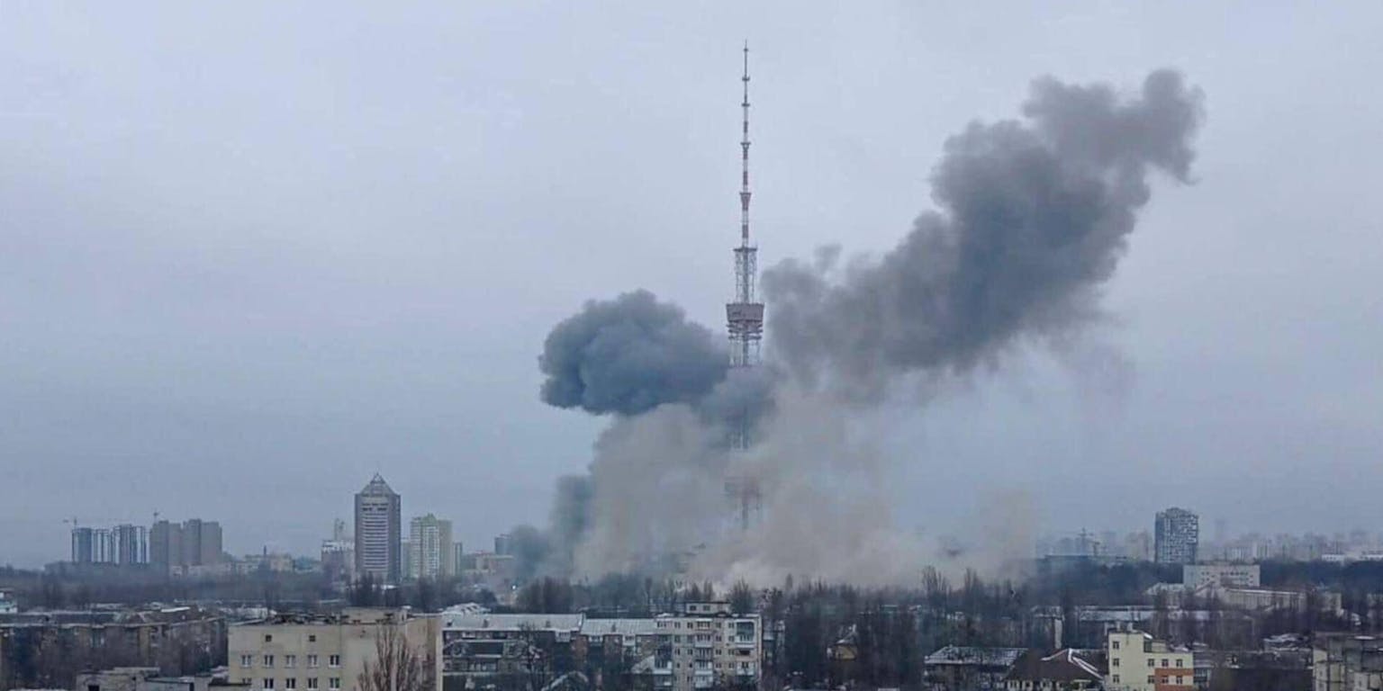 Een zwarte rook stijgt op bij een tv-toren in een stad