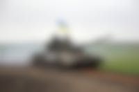 Russische tanks op een weg met bergen op de achtergrond.