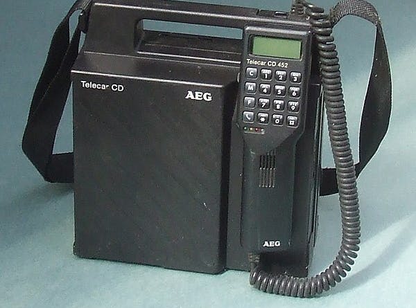 Zwart apparaat met schouder band en telefoon.