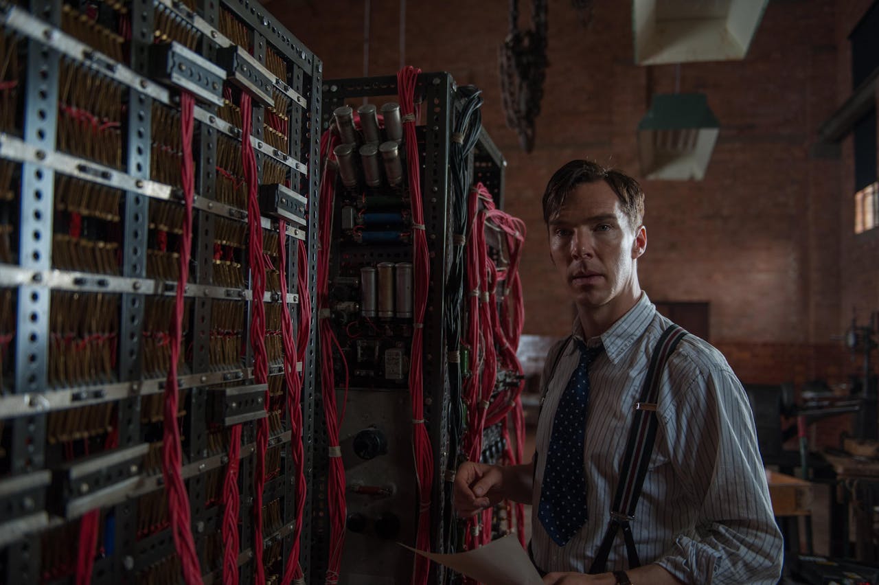 Alan Turing gespeeld door Benedict Cumerbatch in ‘The Imitation Game’. Hij staat bij een kast met allemaal draden.
